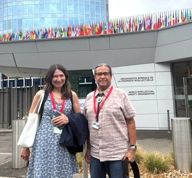 TIP Co-Director, Ms. Sue Noe, and NCAI Pres. Mark Macarro smiling in front of the WIPO Headquarters in Geneva