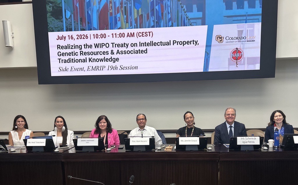 Panelists and commentators sitting at podiums before side event (left to right): Prof. Kristen Carpenter, Ms. Heidi Todacheene, Dr. Sheryl Lightfoot, Pres. Mark Macarro, Ms. Jennifer Tauli Corpuz, Amb. Guilherme de Aguiar Patriota, Ms. Sue Noe